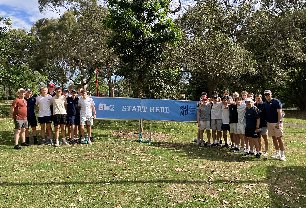 A group of students holding a banner in a park